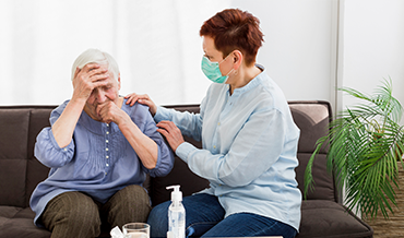 Healthcare professional providing Acute Illness Care Services to an elderly patient at home